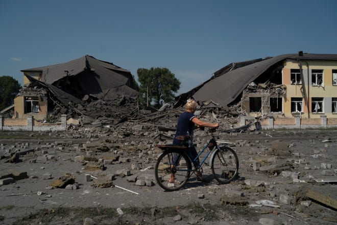 A woman passes a heavily damaged school after a Russian attack in Druzhkivka, Ukraine, on Aug. 30, 2022. Pavlo Kyrylenko, the head of the Donetsk regional military administration, said school No. 8 was completely destroyed.