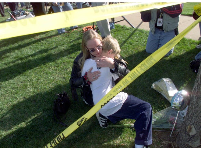 Heather Rosson from Littleton, Colo., hugs her son Daniel as they pay their respects on April 21, 1999, to those who died in the Columbine High School shooting on April 20, 1999. Two heavily armed Columbine students killed twelve fellow students and a teacher and wounded at least twenty others in the attack. The two suspects then took their own lives.