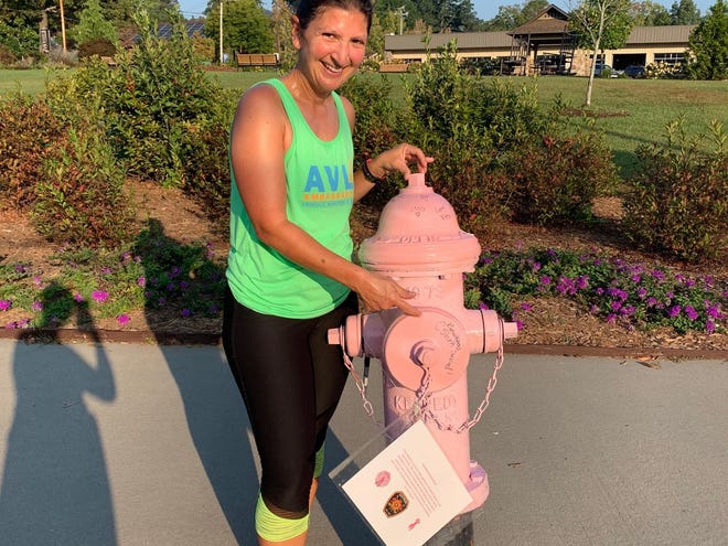 Breast cancer survivor Crystal Shirk signed one of 12 pink fire hydrants around downtown Black Mountain for the Breast Cancer Awareness Month. The hydrants, which can be signed by anyone, will be pink throughout the month of October.