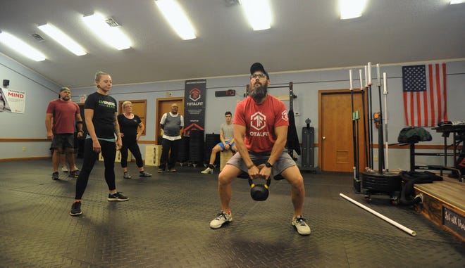 Trent Holbert demonstrates the proper technique for a sumo dead lift using a kettlebell.