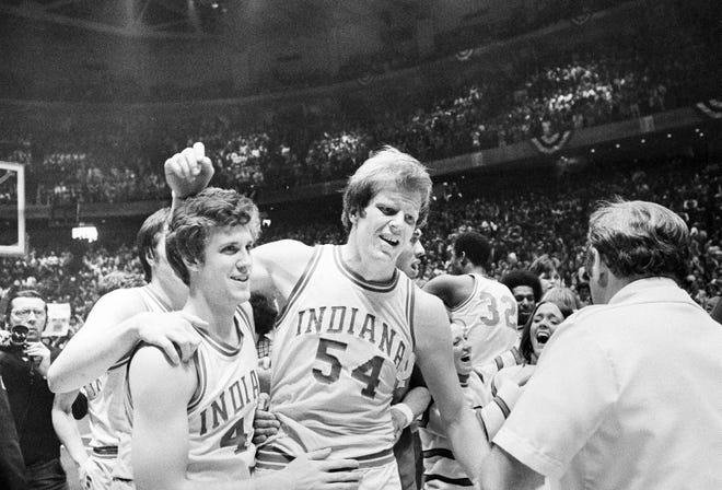 Kent Benson (54), is congratulated by teammate Jim Crews, left, after being named Most Valuable Player of the NCAA basketball tournament in 1976 in Philadelphia. Indiana won the championship over Michigan, 86-68.