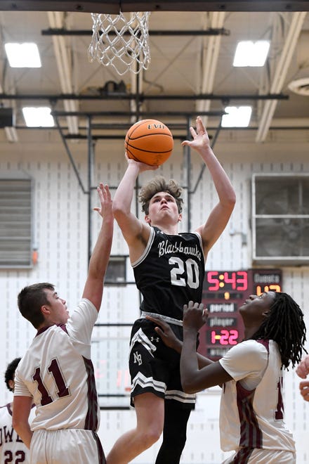 North Buncombe's Bryce Payne goes up for a shot against North Buncombe's Logan Melton, left, and Geordan Haggins, right, during their game at Owen High School on Jan. 2, 2020.