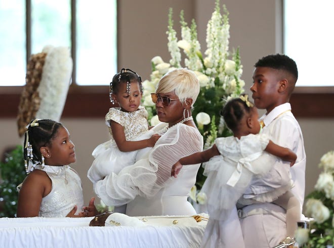 Tomika Miller, wife of Rayshard Brooks, holds their 2-year-old daughter Memory while pausing with her children during the family processional at his funeral in Ebenezer Baptist Church.