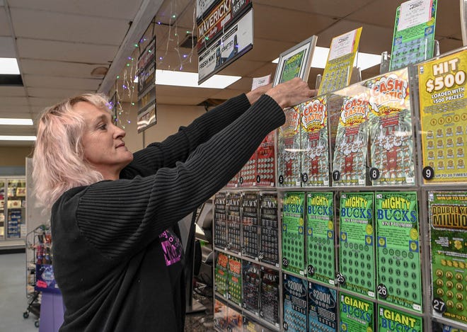 Aggi Tarnowski looks at a copy of a winning lottery scratch-off ticket sold at the KP Food Mart in Anderson, South Carolina. The $350,000 win with a scratch off also meant the store got $3,500, which Tarnowski said the store would put into having Thanksgiving meals to go for the community the store is in. Locals also donated food for the Thanksgiving meals, which the store owners say they will match.