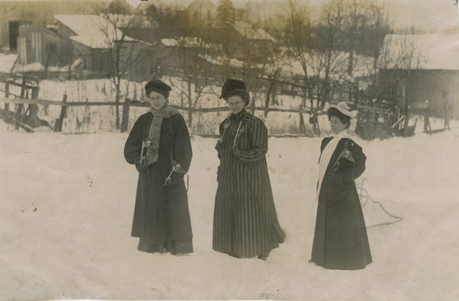 The skates the women carry are of the strap-on variety, dating the photograph to the 1910s or 1920s.